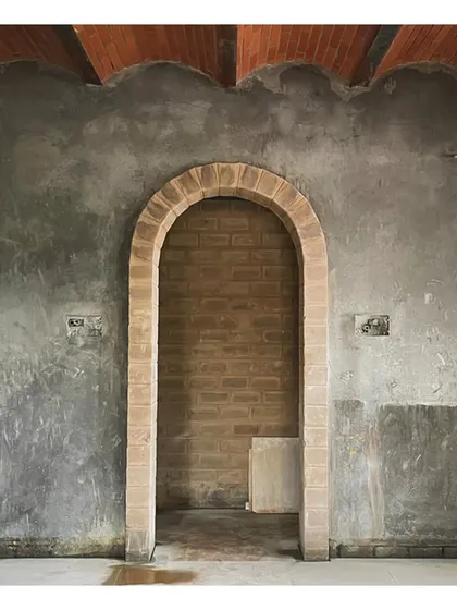 An arched doorway at the 'VKR' site, showcasing the beauty of raw, unfinished materials.