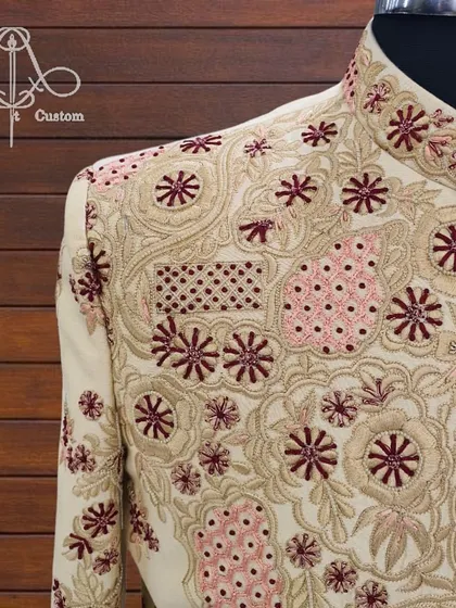 The royalty of my outfits is in the details. This close-up shows the intricate, multi-colored hand embroidery on one of my bespoke sherwanis. Every thread is a testament to the quality and craftsmanship I promise.