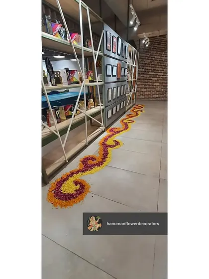 This floral rangoli path was designed to complement the modern, industrial aesthetic of the office interior. The traditional art form adds a soft, organic touch to the space.