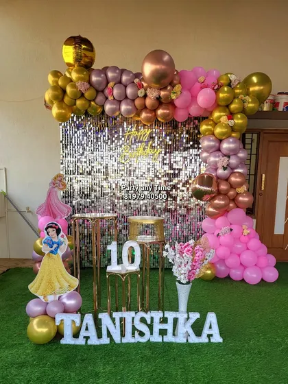 For Tanishka's 10th birthday, I created this princess theme with a silver shimmer wall and a pink and gold balloon arch. The setup includes princess cutouts and light-up letters for the name.