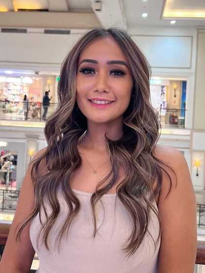 A happy client showing off her new balayage. This look features a beautiful blend of tones that create a natural, sun-kissed effect, perfect for any season.