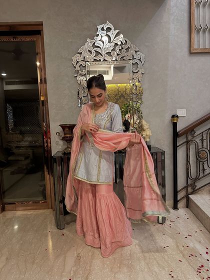 This sharara set features a beautiful combination of a powder blue kurta with delicate embroidery and a soft pink sharara. It's a wonderful example of pastel ethnic wear for daytime events.