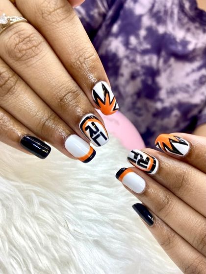 Nailed it. This bold, graphic set features a mix of black, white, and orange with sharp lines and what looks like a custom logo, perfect for game day or showing team spirit.