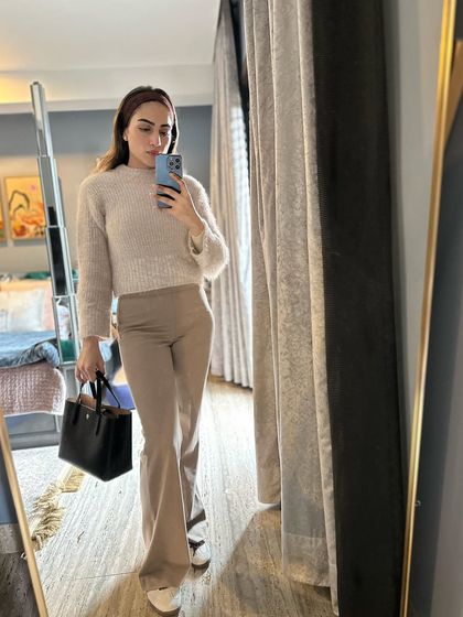 A cozy winter outfit with a beige sweater and matching pants.