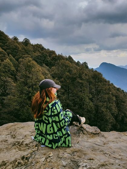 A quiet moment overlooking the lush green hills of Jibhi, showing a different, greener side of Himachal.