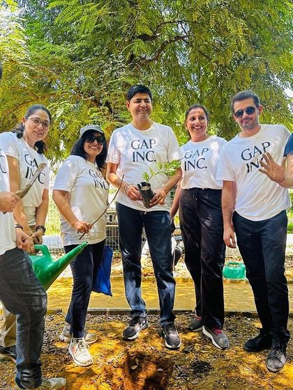 Smiles all around as the Gap Inc. team gets ready to plant and water native saplings, turning corporate social responsibility into tangible green action.