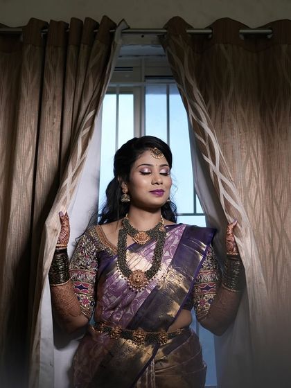 Aarthi looking serene and beautiful for her reception. The makeup features a bold magenta lip and shimmery eyeshadow.