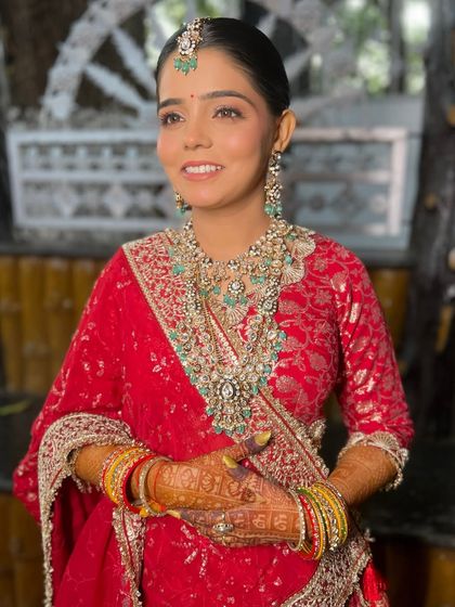 A full view of the stunning red lehenga, with makeup kept soft and classic to match.