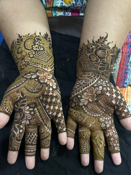 An intricate semi-bridal design with a mix of traditional and floral elements. The patterns are dense on the hands for a rich look.