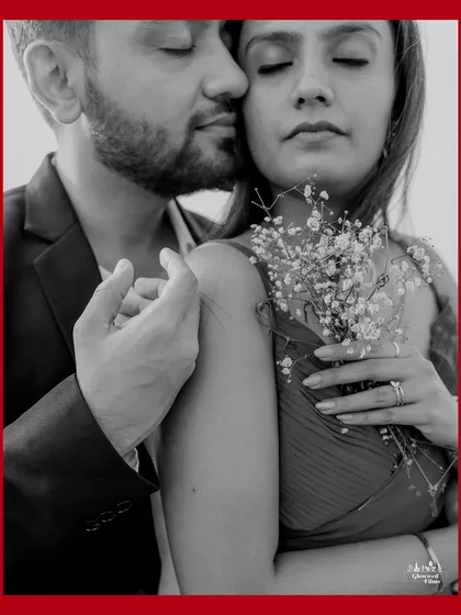 A tender black and white close-up, where the couple's eyes are closed in a moment of quiet connection. The delicate baby's breath flowers add a touch of softness and romance to this intimate portrait.