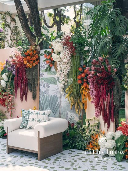 The seating area for the 'Garden of Gaia' ceremony, with a comfortable armchair set against the stunning floral backdrop.