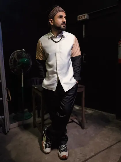 A full-body look at the Maison Tai color-blocked shirt on Vir Das. Paired with relaxed black trousers and stylish sneakers, this outfit is a great example of contemporary smart-casual styling for an artist.