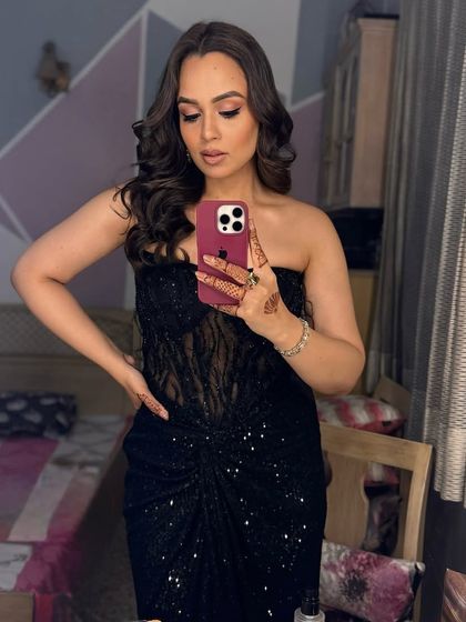 A selfie moment in a stunning black gown. For this reception look, I created a contoured and highlighted face with a sharp wing liner and beach waves.