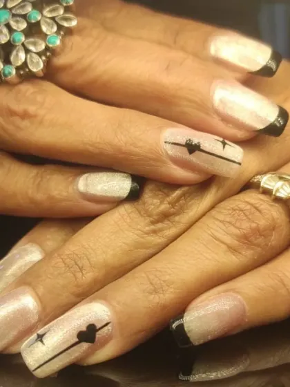 A full view of the modern black-tipped French manicure with delicate line art.