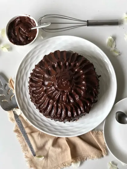 An overhead view of my dense chocolate cake, completely covered in rich, swirling chocolate ganache. It's as delicious as it looks.