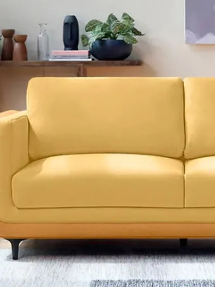 A close-up of one of our modern sofas, shown here in a vibrant yellow fabric with a contrasting tan base. The clean lines and slim legs are perfect for contemporary homes.