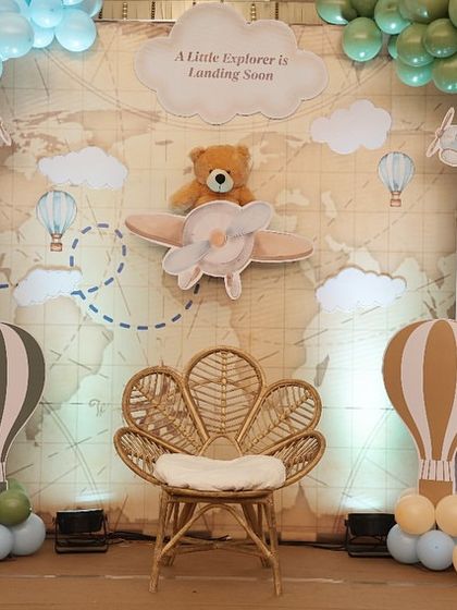 The centerpiece of our 'Little Explorer' backdrop. A cute teddy bear pilot flies over a world map, setting a whimsical and adventurous tone for the baby shower celebration.