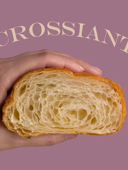 A close-up of a croissant cross-section, showing the beautiful, airy layers inside. This is a technical shot that showcases the baker's skill.