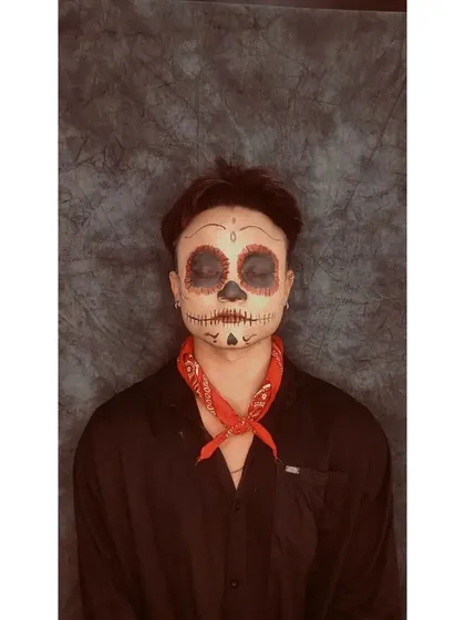 A sugar skull makeup look inspired by the film Coco. This design features classic Día de los Muertos elements, including symmetrical patterns around the eyes, a stitched mouth, and delicate details on the chin and forehead.