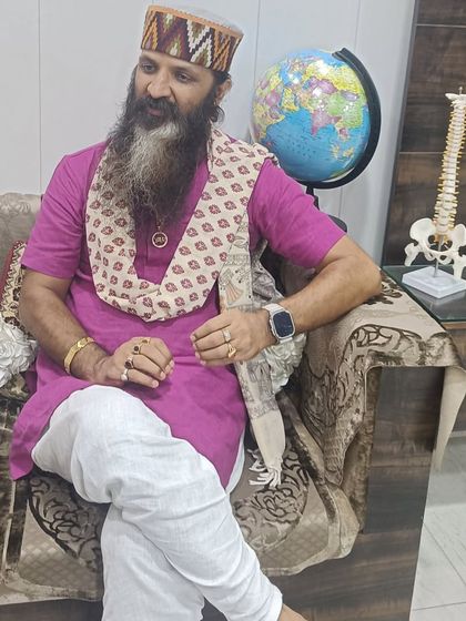 A candid photo of me sitting in my office, with a model of the human spine and a globe nearby. This represents my work, which is about the health of the human body and my connection to the whole world.