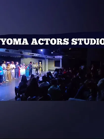 A wide shot of a student showcase, capturing the moment the cast receives their certificates on stage in front of a full house.