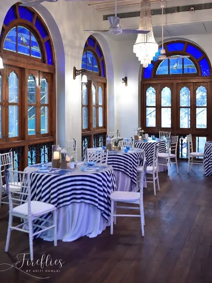 The tables at the Royal Bombay Yacht Club were set with striped linens and nautical details. The historic venue with its arched windows provided the perfect backdrop for this maritime-themed celebration.