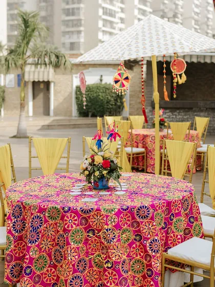 A close-up of a guest table with its phulkari-inspired tablecloth and a unique floral centerpiece. Every detail is curated to match the vibrant theme.