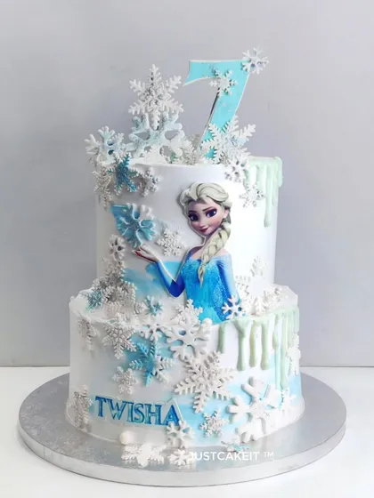 This elegant two-tiered Frozen theme cake shows how I can create a magical design using minimal fondant. The delicate edible snowflakes and airbrushed colors bring the wintery theme to life.
