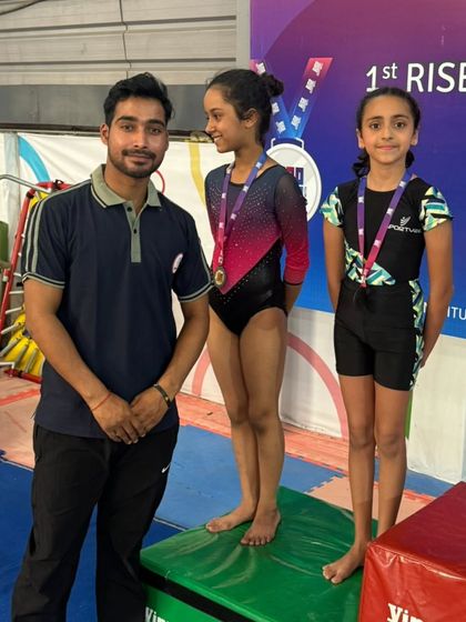 A coach and his successful students on the podium. This image captures the strong partnership that leads to success in competitive kids gymnastics.