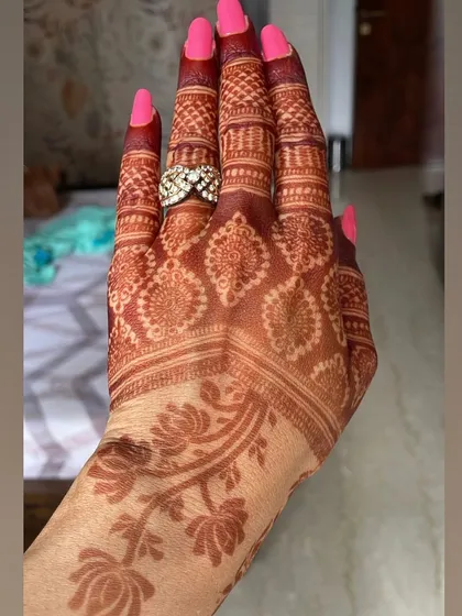 A close-up of the fingers, showing the deep, even color of the henna stain.