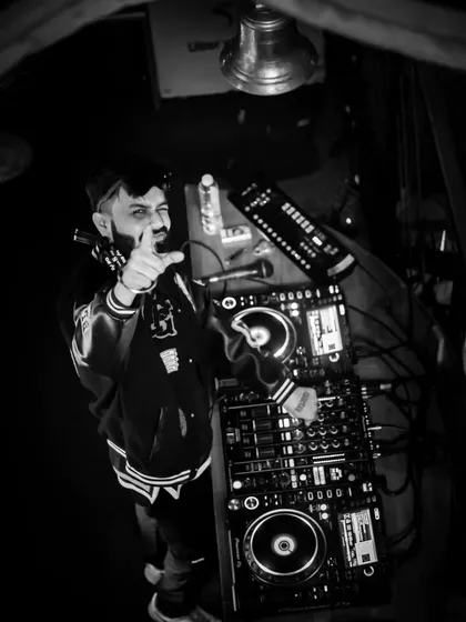 A black and white shot from above the console. It captures the focus and control required to manage the energy of a packed club.