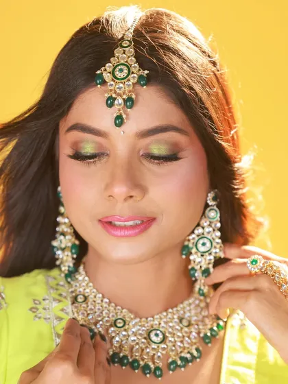 A close-up beauty shot focusing on the model's makeup. The soft lighting is ideal for highlighting the details of the eye shadow and the intricate jewellery.