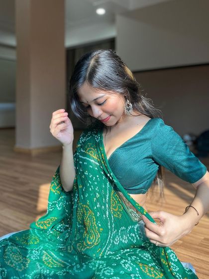 A gentle, downward glance, capturing the intricate details of the bandhani saree.