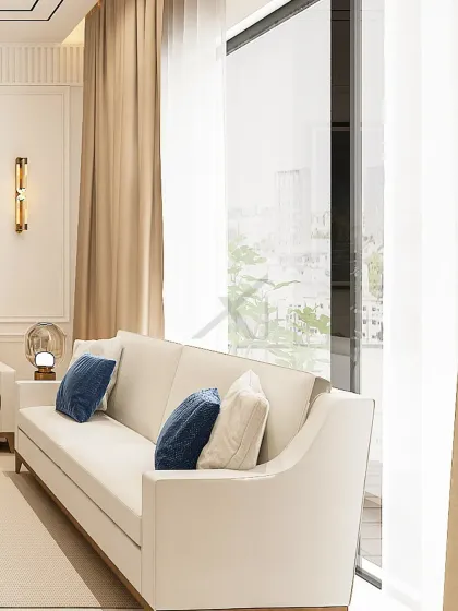 The clean lines of the sofa are set against full-height windows, offering an expansive city view. Brass wall sconces add a touch of warmth and luxury.