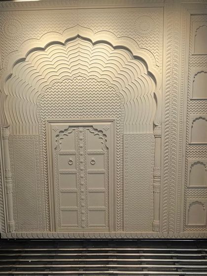 This intricately carved stone panel replicates the grandeur of a traditional Indian jharokha and doorway. It's a perfect example of how we use modern techniques to honor classic design for mandirs or heritage-themed spaces.