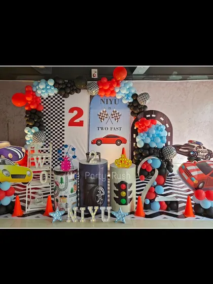 Ready, set, go! For Niyu's "Two Fast" second birthday, I created a high-energy race car theme. The setup includes a checkered flag backdrop, car cutouts, and fun details like traffic light plinths and road-cone accents to get everyone's engines running.