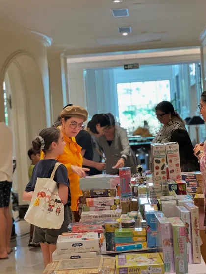 A mother and daughter browse a stall filled with educational toys and games, showing the family-friendly nature of our events.