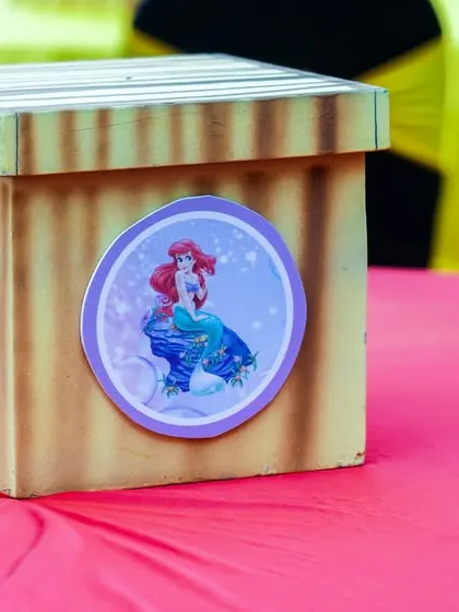 A themed centerpiece box for the Mermaids vs. Pirates party, featuring both Ariel and a pirate character.