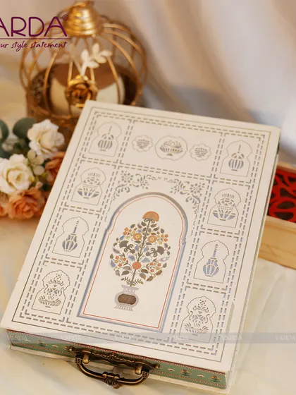 This beautiful keepsake box features a hand-painted floral motif inspired by Mughal art, set within a traditional arch design. The antique-style handle adds to its charm as a reusable decorative piece.