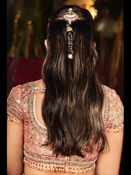 A close-up on the back of the Tarun Tahiliani blouse and the intricate hair accessory. The detailed beadwork and elegant hairstyle are key components of this look.