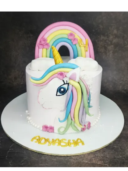 A unicorn face cake with a handmade fondant horn and rainbow mane. This is an eggless black forest cake filled with a homemade fresh cherry compote.