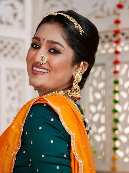The joy of a bride is everything. This candid shot captures her beautiful smile, enhanced by a natural makeup look and traditional Maharashtrian styling.