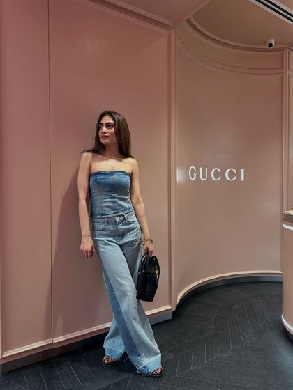 A side profile of the denim corset and jeans look. This outfit proves that denim can be dressed up for a chic evening look.