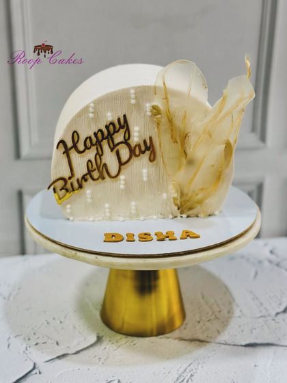 A modern cake top-forward design, this creation is adorned with a delicate rice paper sail for a touch of ethereal beauty.