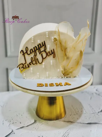 A modern cake top-forward design, this creation is adorned with a delicate rice paper sail for a touch of ethereal beauty.