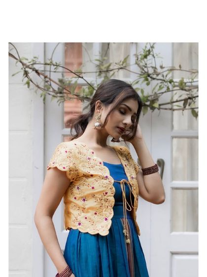 The dress is paired with a contrasting yellow hand-embroidered jacket with scalloped edges, adding a bright and cheerful touch.