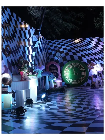 I love bringing imaginative themes to life. For this Mehndi, I designed a surreal 'Alice in Wonderland' experience, complete with a dizzying checkered floor, oversized clocks, and whimsical props to transport guests to another world.