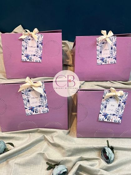 A set of our elegant pastel purple gift bags used for wedding favours. Each bag is personalised with a custom floral tag bearing the guest's name for a special touch.