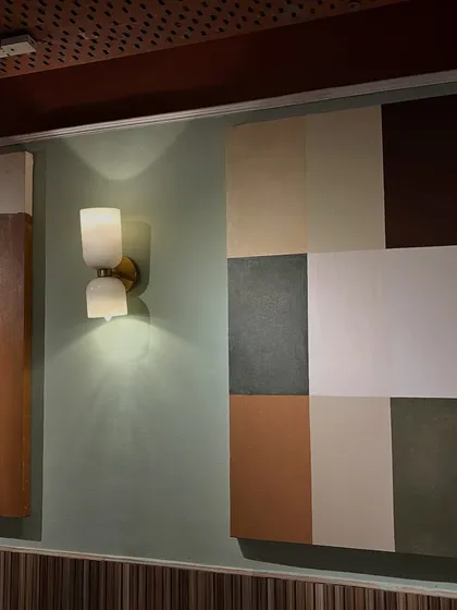 An installation view of two abstract pieces at Sidewalk, Kanpur. The color block painting on the right adds a modern, geometric touch to the wall.