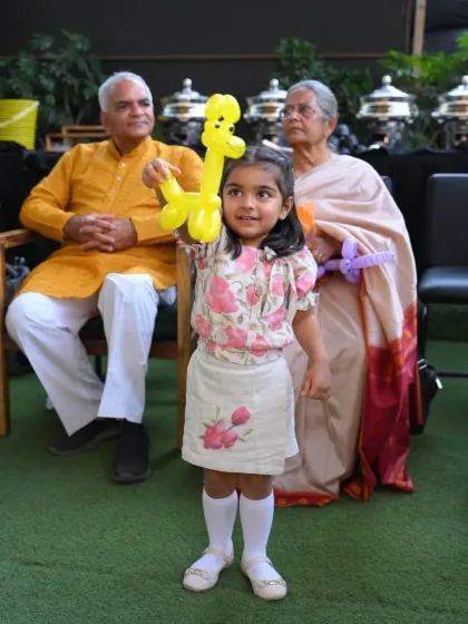 Our balloon twisting artists are always a party favorite. This little girl proudly shows off her yellow giraffe, one of the many fun creations our artists can make for guests to take home.
